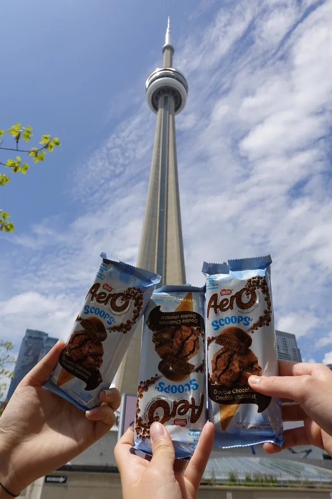 Holding up snacks in front of the CN Tower